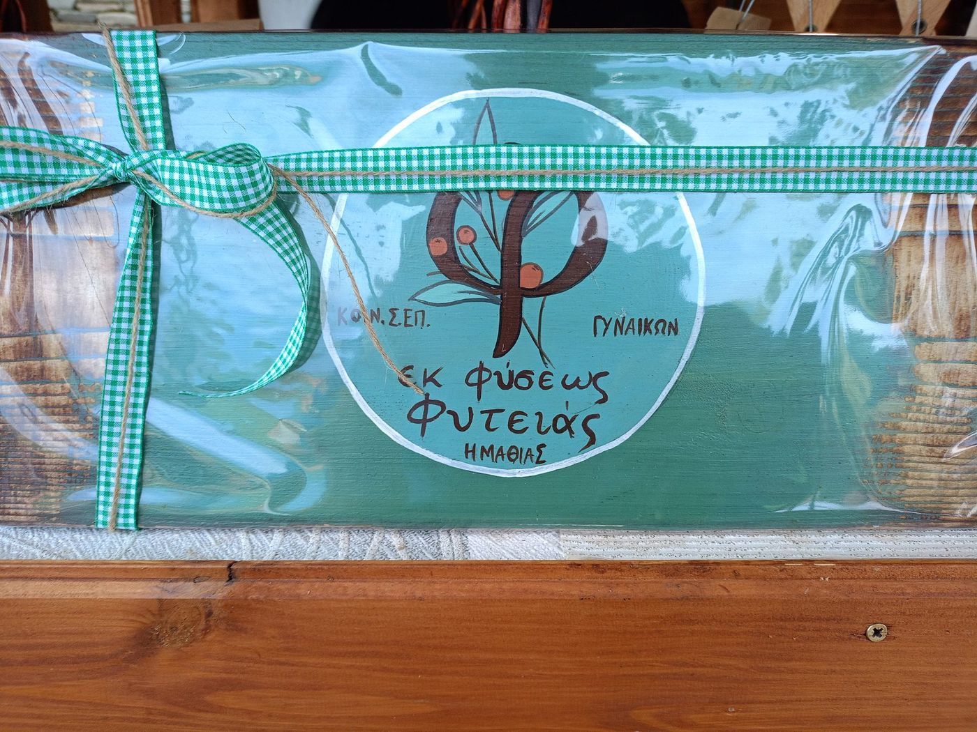 A gift box tied with a green gingham ribbon and the cooperative's label.